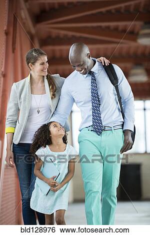 Stock Photograph - Family walking together on walkway. Fotosearch