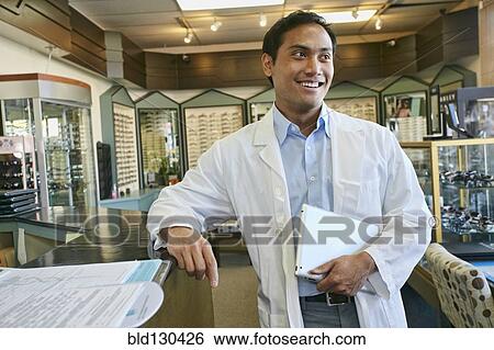 Stock Photograph - Filipino optometrist smiling in office. Fotosearch