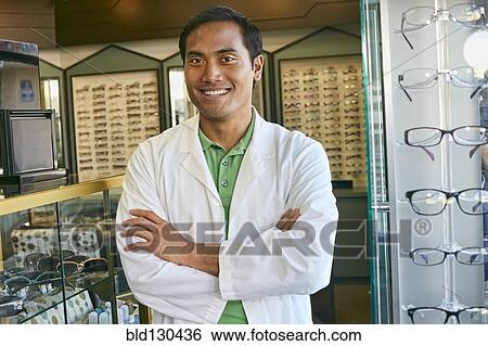 Filipino optometrist smiling in office View Large Photo Image Stock Photograph - Filipino optometrist smiling in office. Fotosearch