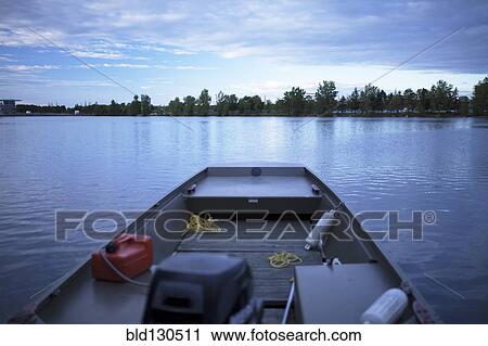 Stock Image - Fishing boat on still rural lake. Fotosearch