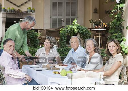 Friends eating together outdoors View Large Photo Image Picture - Friends eating together outdoors. Fotosearch