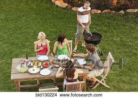 Picture - Friends eating together outdoors. Fotosearch