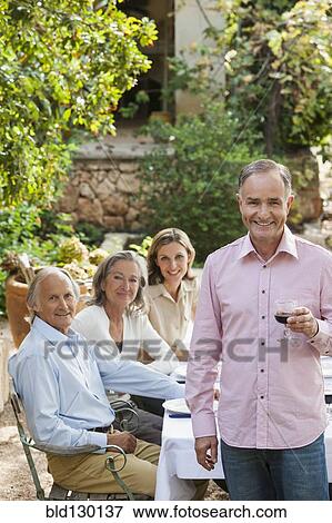 Stock Photo - Friends eating together outdoors. Fotosearch