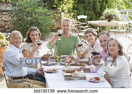 Stock Photo - Friends eating together outdoors. Fotosearch
