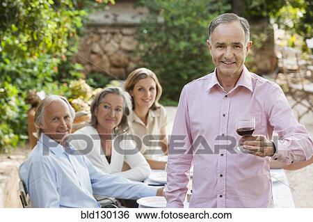Stock Photograph - Friends eating together outdoors. Fotosearch