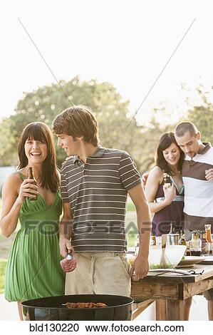 Friends having barbecue outdoors View Large Photo Image Stock Image - Friends having barbecue outdoors. Fotosearch