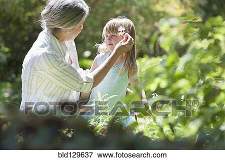 Stock Photo - Grandmother and granddaughter picking flowers. Fotosearch