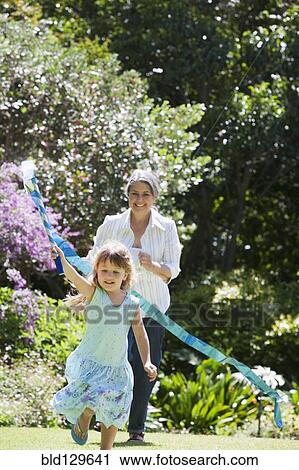 Grandmother and granddaughter playing in garden View Large Photo Image Stock Image - Grandmother and granddaughter playing in garden. Fotosearch