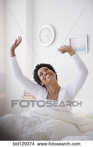 Picture - Happy Black woman awaking in bed. Fotosearch