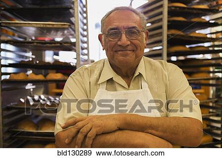Hispanic baker working in commercial kitchen View Large Photo Image Stock Photo - Hispanic baker working in commercial kitchen. Fotosearch