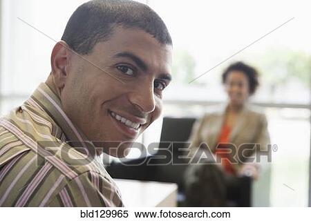 Stock Photography - Hispanic businessman smiling in office. Fotosearch