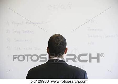 Hispanic businessman standing at whiteboard View Large Photo Image Stock Image - Hispanic businessman standing at whiteboard. Fotosearch