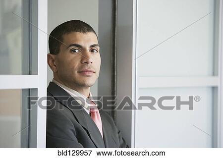 Stock Photo - Hispanic businessman standing in doorway. Fotosearch