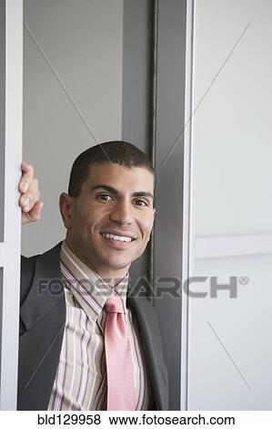 Stock Photo - Hispanic businessman standing in doorway. Fotosearch