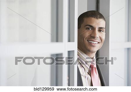 Stock Photo - Hispanic businessman standing in doorway. Fotosearch