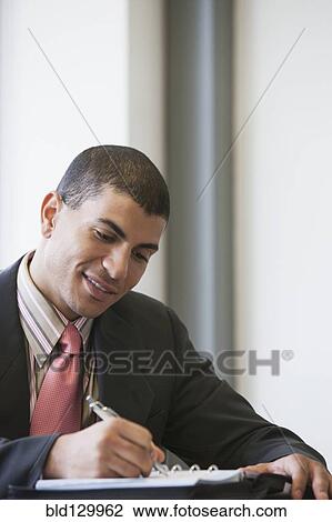 Stock Image - Hispanic businessman working in office. Fotosearch