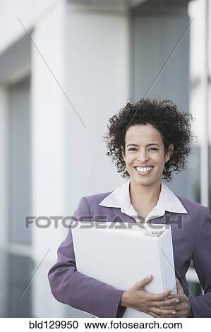 Hispanic businesswoman carrying large binder View Large Photo Image Stock Image - Hispanic businesswoman carrying large binder. Fotosearch