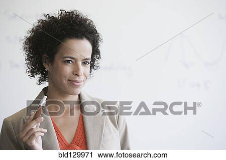 Stock Image - Hispanic businesswoman holding whiteboard marker. Fotosearch