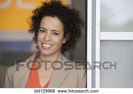 Stock Photo - Hispanic businesswoman smiling in doorway. Fotosearch