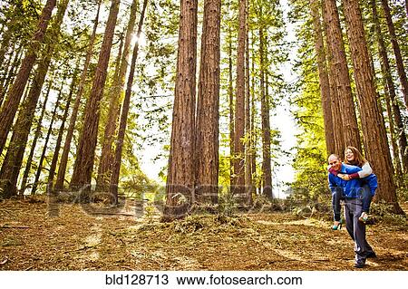 Hispanic man carrying girlfriend piggy back in forest View Large Photo Image Stock Image - Hispanic man carrying girlfriend piggy back in forest. Fotosearch