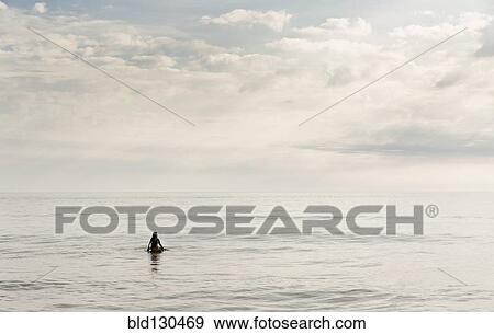 Stock Photo - Hispanic surfer floating in water. Fotosearch