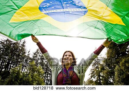 Stock Photo - Hispanic woman flying Brazilian flag. Fotosearch