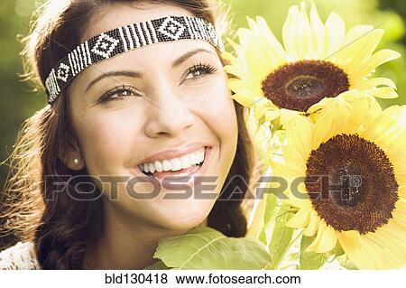 Stock Photo - Hispanic woman holding sunflowers. Fotosearch