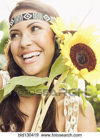 Stock Photo - Hispanic woman holding sunflowers. Fotosearch