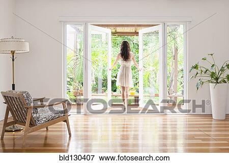 Hispanic woman opening French doors to patio View Large Photo Image Stock Photo - Hispanic woman opening French doors to patio. Fotosearch