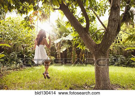 Hispanic woman sitting on tree swing View Large Photo Image Picture - Hispanic woman sitting on tree swing. Fotosearch