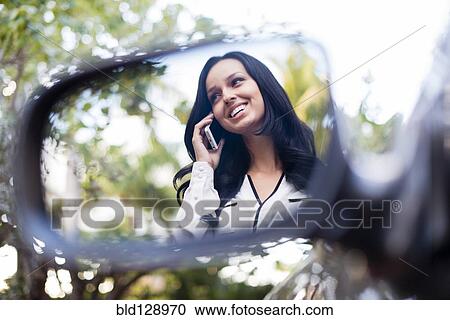 Stock Image - Hispanic woman talking on cell phone. Fotosearch