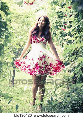 Hispanic woman walking in lush backyard View Large Photo Image Stock Image - Hispanic woman walking in lush backyard. Fotosearch