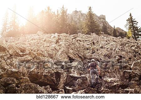 Man climbing rocky hillside View Large Photo Image Stock Photo - Man climbing rocky hillside. Fotosearch