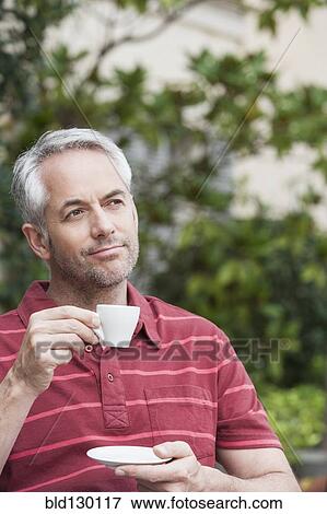 Stock Photo - Man drinking espresso outdoors. Fotosearch