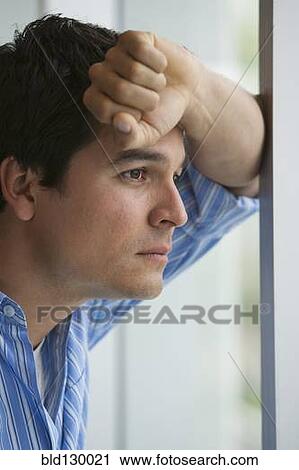 Stock Image - Man looking out window. Fotosearch