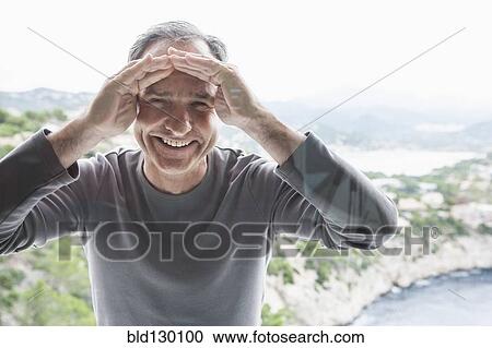 Stock Image - Man peering through window. Fotosearch