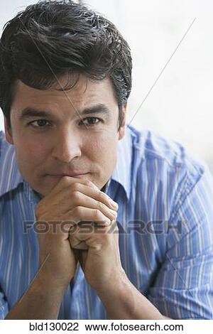 Stock Image - Man sitting with chin in hands. Fotosearch