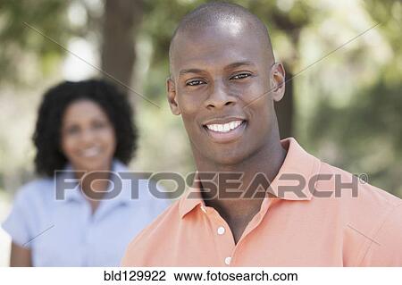 Stock Image - Man smiling in park. Fotosearch