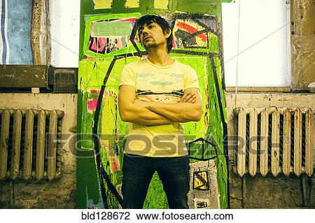 Stock Image - Mari artist standing in front of painting. Fotosearch