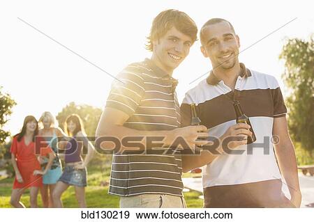 Stock Photo - Men drinking beer together at party. Fotosearch
