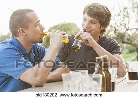 Men drinking beer together outdoors View Large Photo Image Stock Image - Men drinking beer together outdoors. Fotosearch