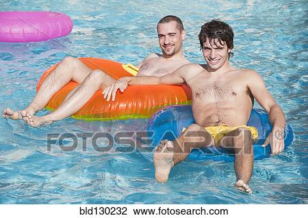 Men floating in inner tubes in swimming pool View Large Photo Image Stock Image - Men floating in inner tubes in swimming pool. Fotosearch
