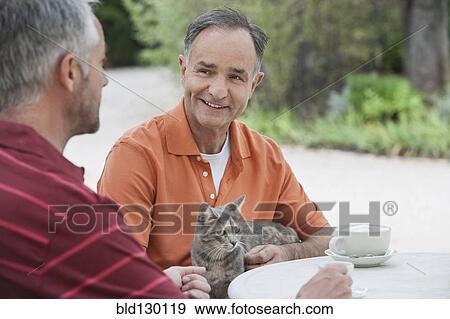 Stock Photo - Men having coffee together outdoors. Fotosearch