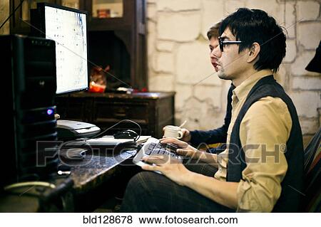 Stock Photo - Men using computer at desk. Fotosearch