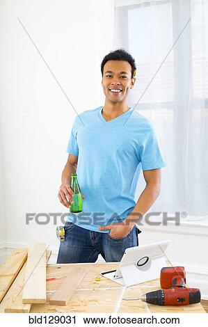 Mixed race carpenter drinking sparkling water View Large Photo Image Stock Image - Mixed race carpenter drinking sparkling water. Fotosearch