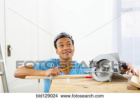 Mixed race carpenter marking wood View Large Photo Image Picture - Mixed race carpenter marking wood. Fotosearch