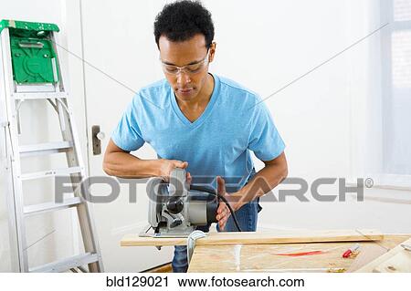 Mixed race carpenter using hand saw View Large Photo Image Stock Image - Mixed race carpenter using hand saw. Fotosearch