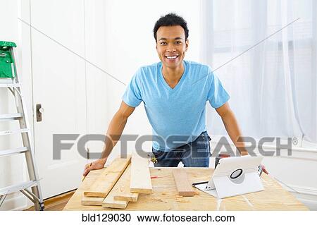 Stock Image - Mixed race carpenter working. Fotosearch
