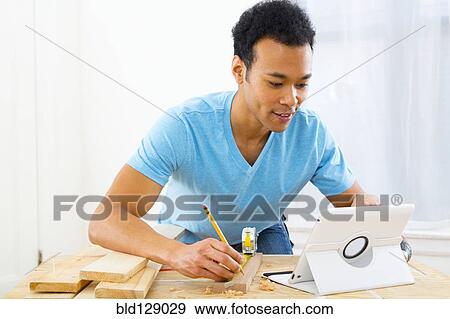 Mixed race carpenter working with digital tablet View Large Photo Image Stock Photo - Mixed race carpenter working with digital tablet. Fotosearch