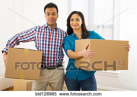 Mixed race couple carrying cardboard boxes in new home View Large Photo Image Stock Photography - Mixed race couple carrying cardboard boxes in new home. Fotosearch